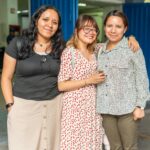 Three friends posing happily together indoors, showcasing friendship and joy.